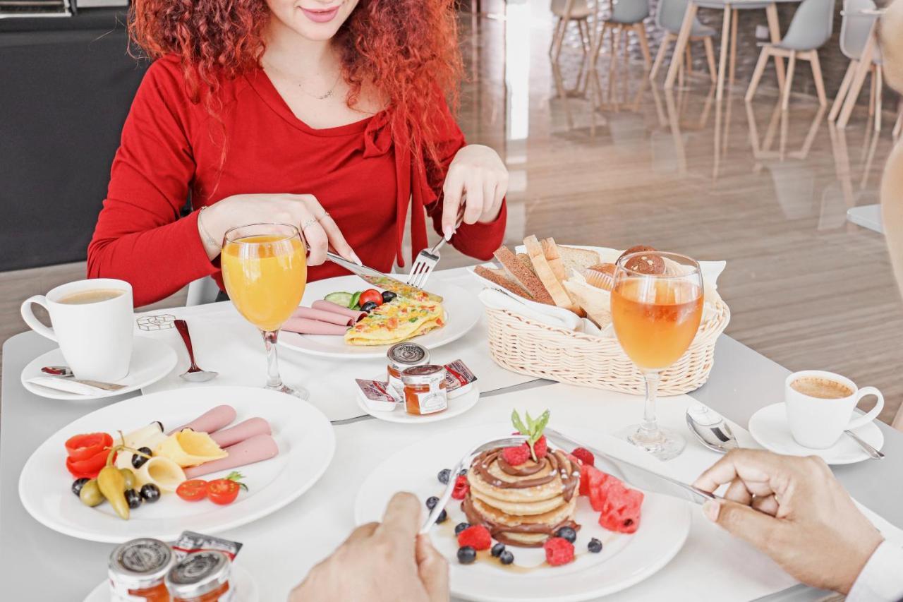 The Bentley Luxury Hotel & Suites Доха Экстерьер фото A woman eating breakfast